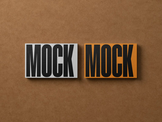 Two business card mockups side by side, gray MOCK and orange MOCK variants