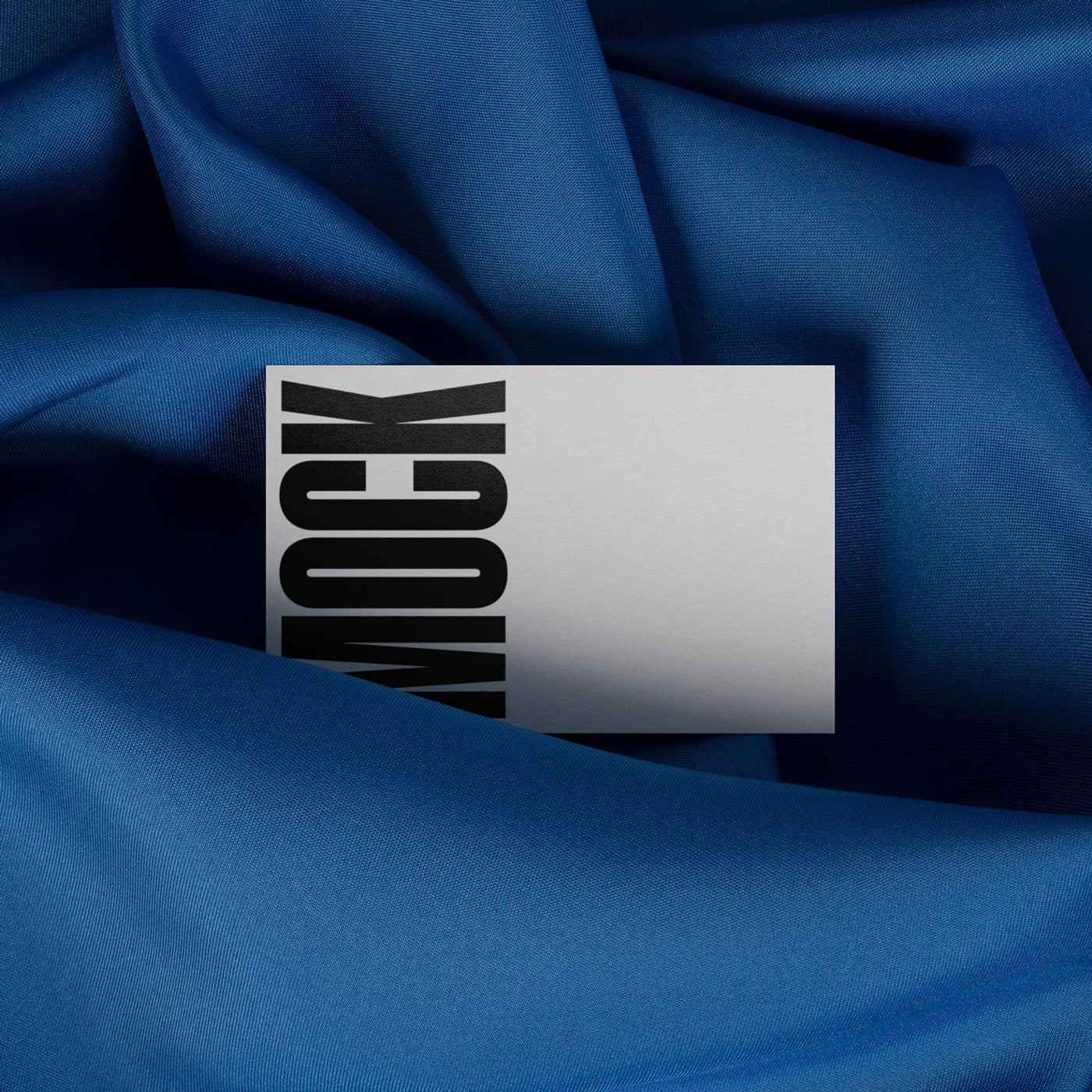Blue draped cloth with partially visible white stationery card and black branding block