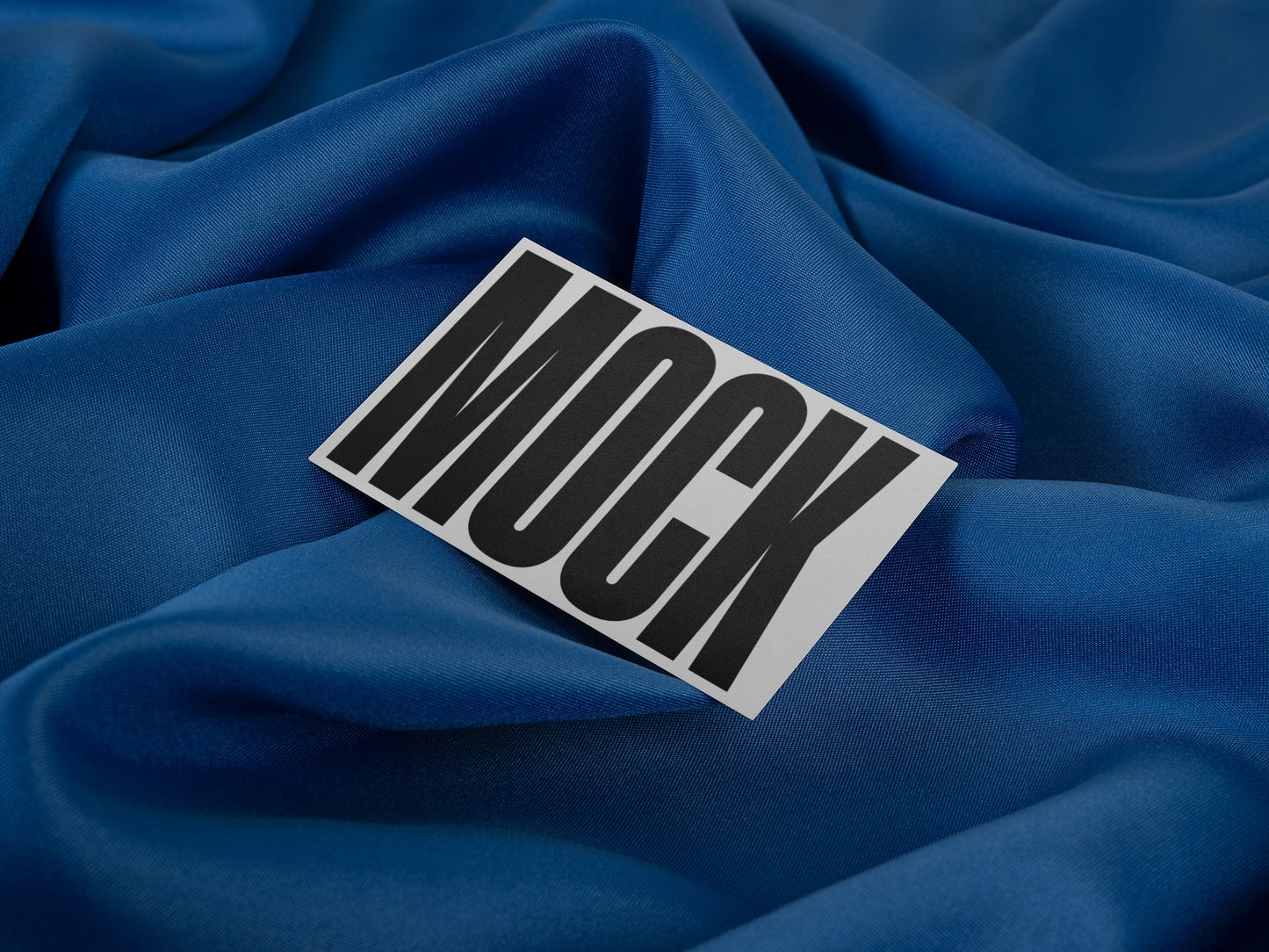 Branding mockup featuring stationery print items, showing a business card design on a blue background made of cloth fabric. Created by Sylvan Hillebrand.