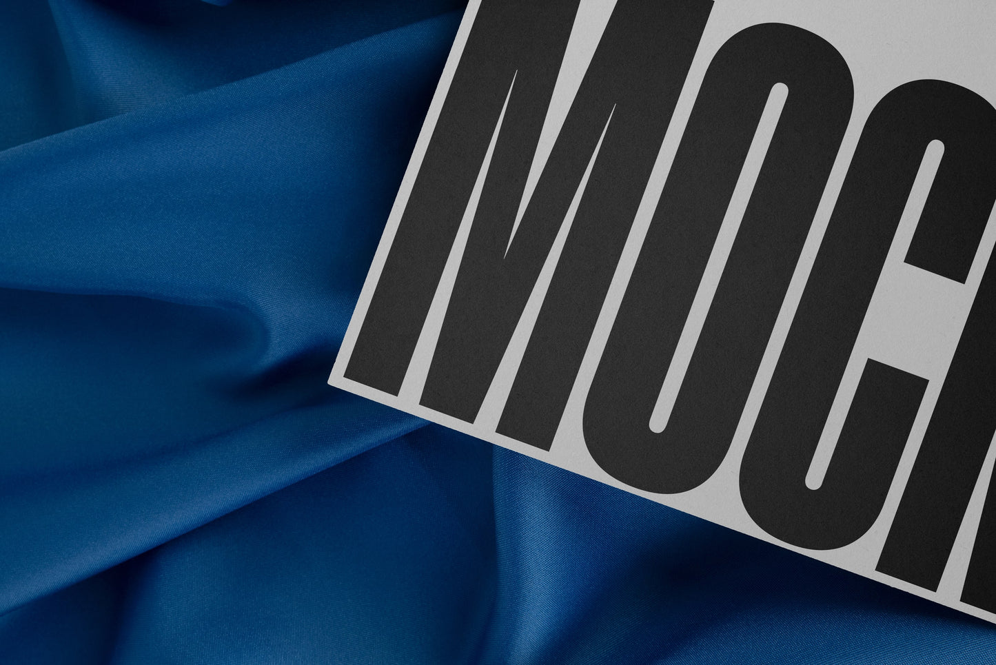 High-quality branding mockup featuring stationery print items, showing a poster on a blue background made of cloth fabric. Created by Sylvan Hillebrand.